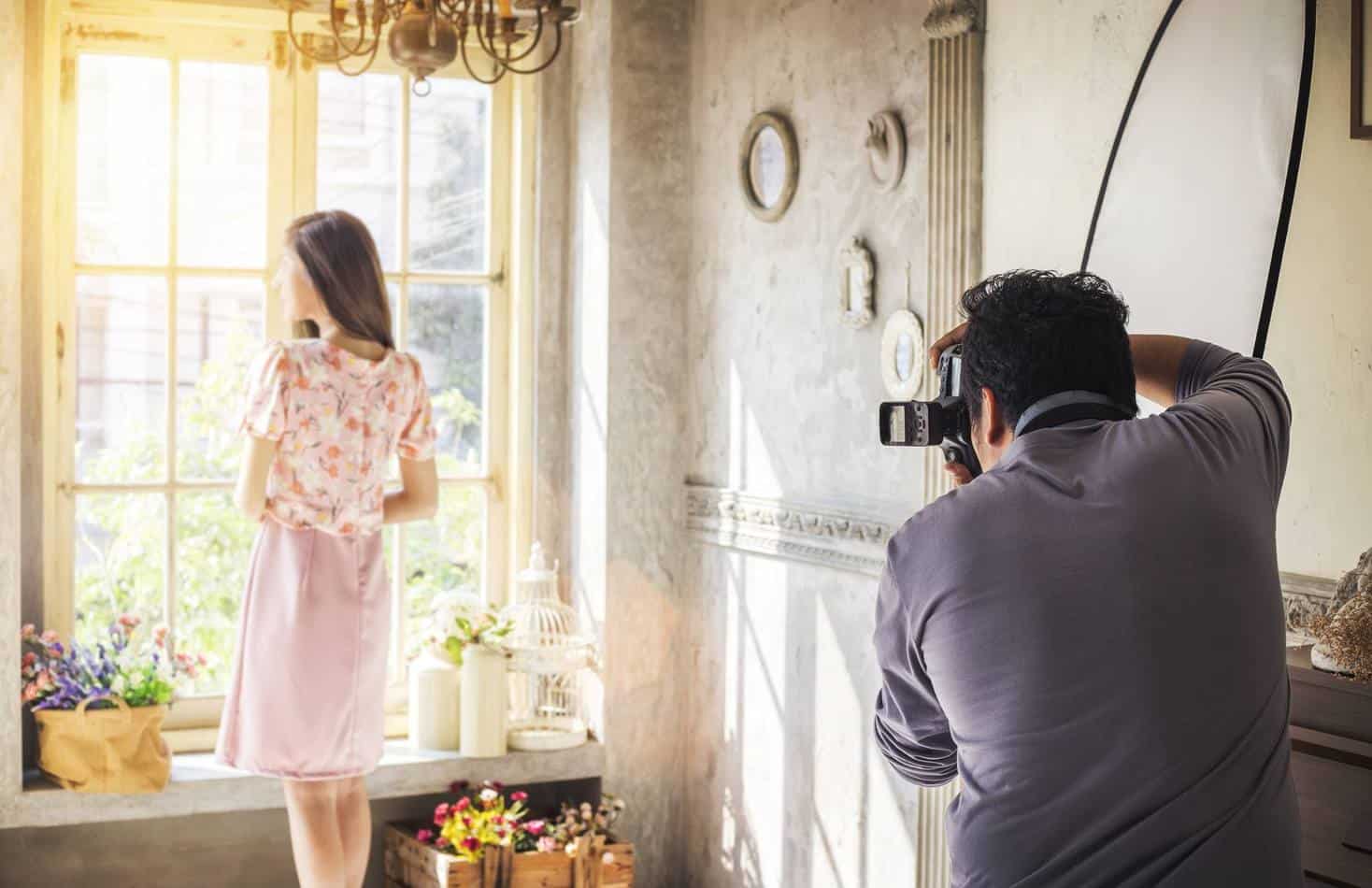 Professional Photographer Taking a Portrait of a Fashion Model at Vintage Interior Studio Location with Morning Light
